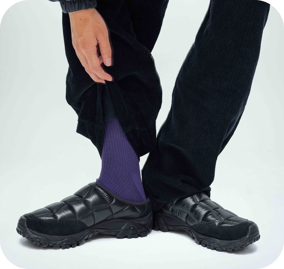 Model in black slides with purple socks